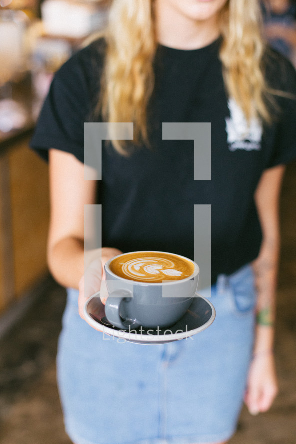 woman holding cappuccino in a mug 