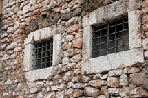 Hand made antique prison bars in stone walls.