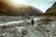 Men walking near a river through the mountains.