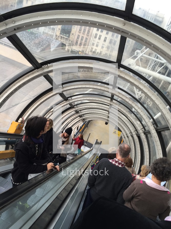 people riding an escalator 