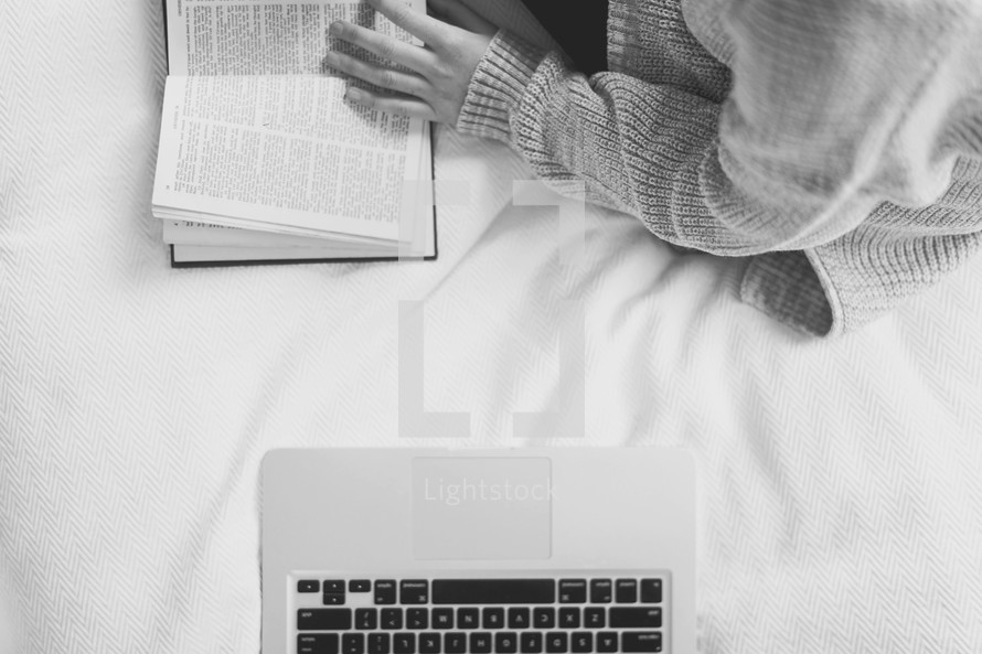 laptop computer and woman reading a Bible in bed 