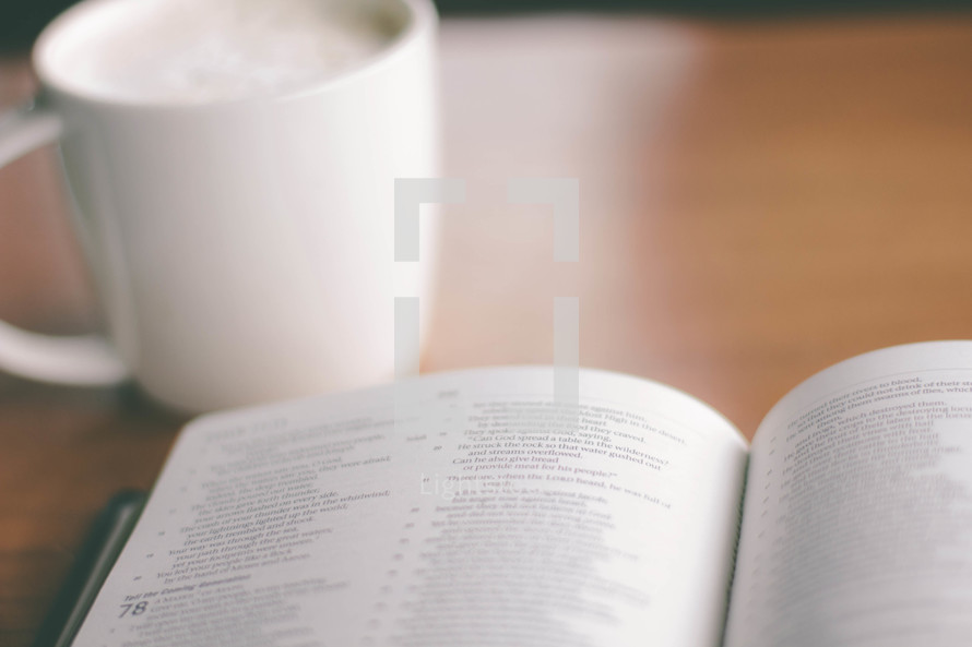 coffe cup and an open Bible