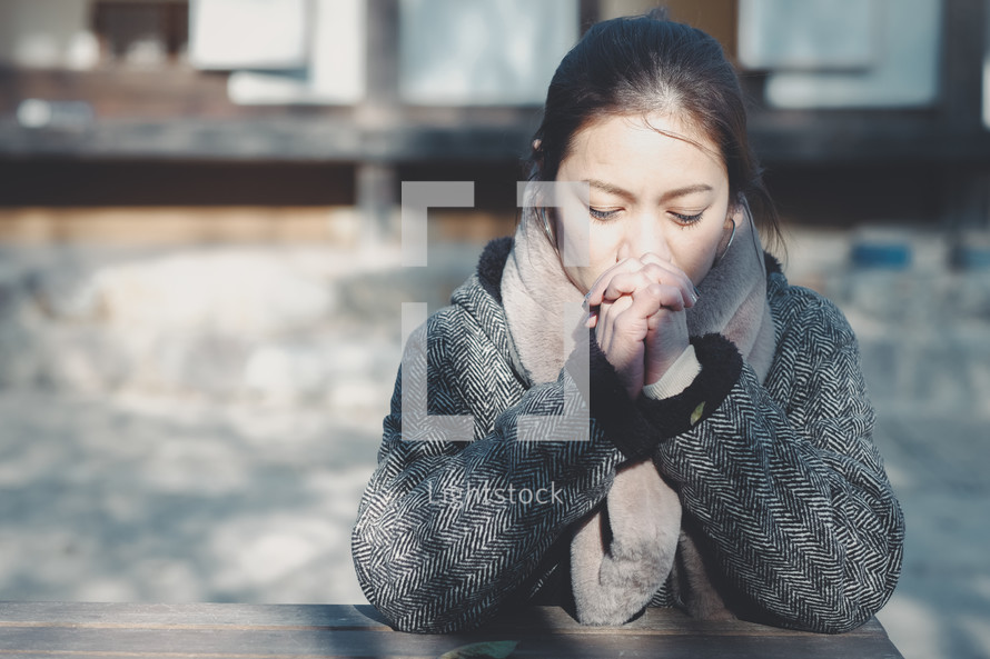 young woman praying alone outdoors 