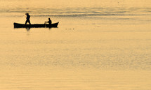 silhouette of fishermen with and orange sun on Danbe river