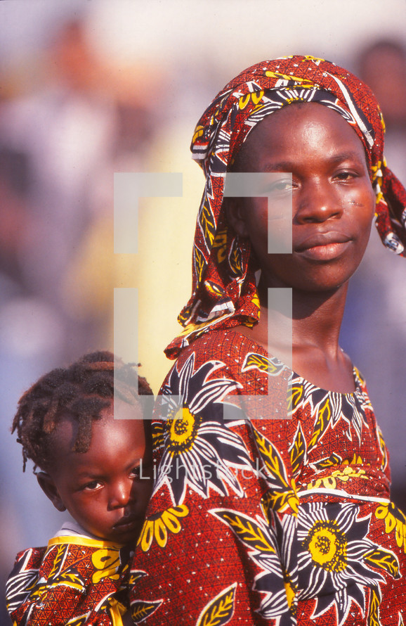African woman and child in traditional clothing with child on her back