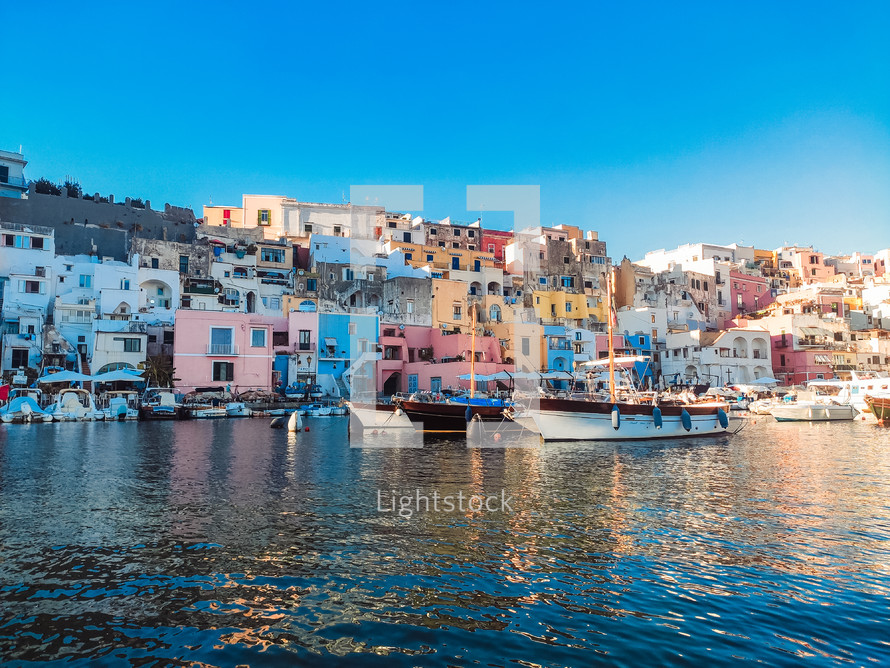 Procida island port with boats at sunset summer sky