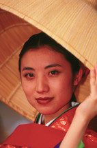 Japanese woman in kimono under a straw hat 