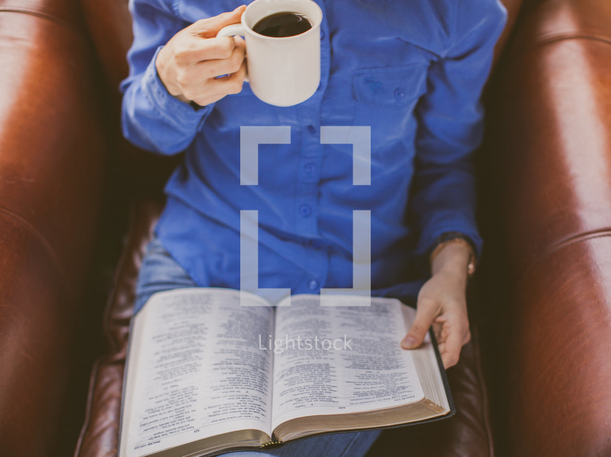 A woman drinking coffee reading a Bible 