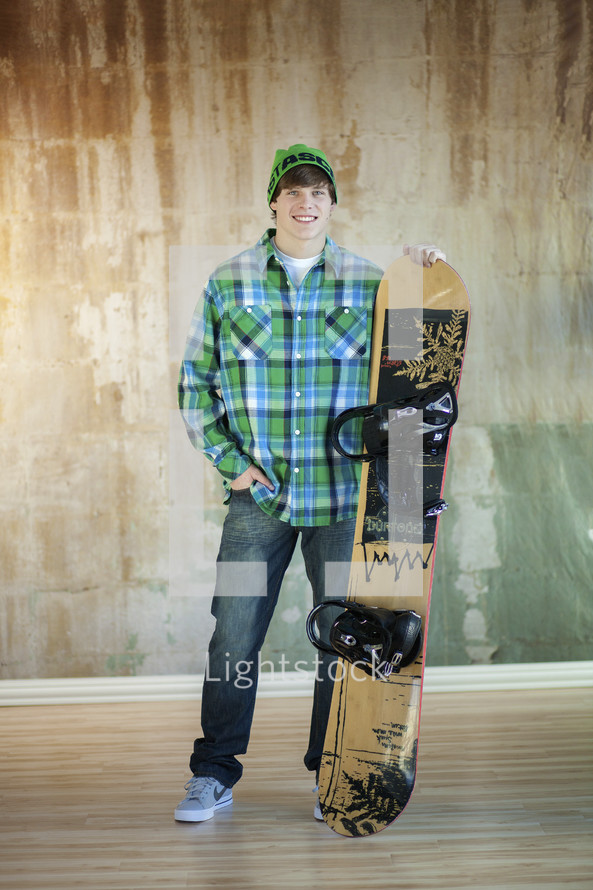 young man standing with a snow board 