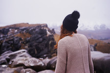 woman walking over rocks on a mountain 