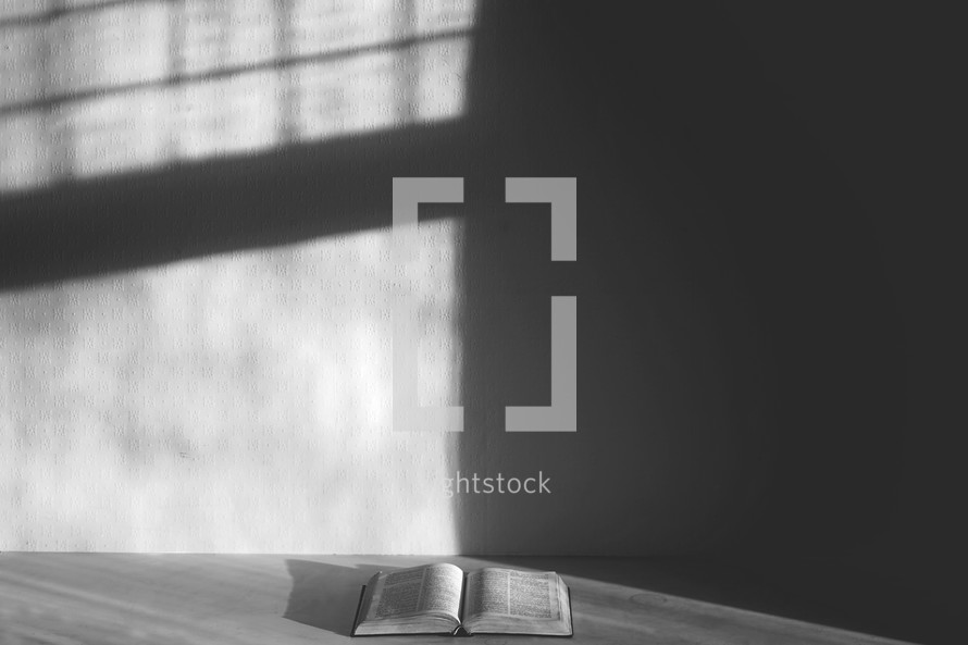 open Bible in the corner of an empty room 