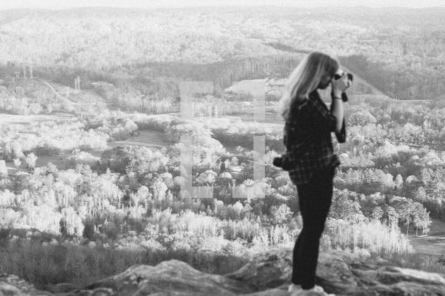 woman with a camera on a mountain top 