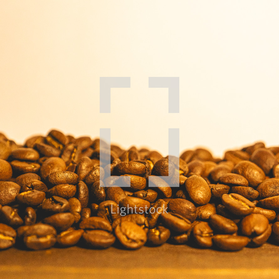 Bunch of coffee beans on a table with a light background.