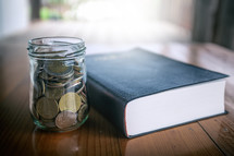 mason jar with coins and Bible 