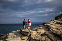 a man proposing on a rocky shore 