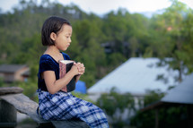 a girl holding a Bible praying 