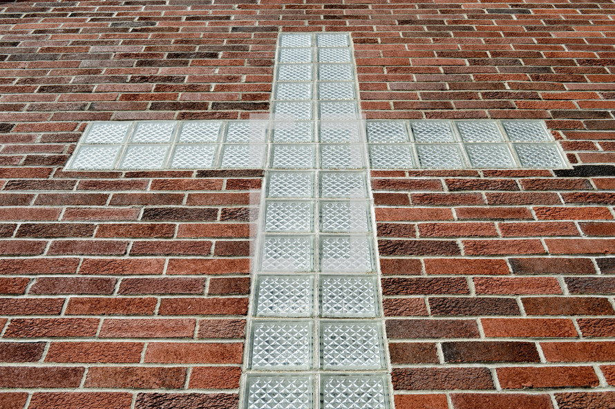 glass block cross against a brick wall 