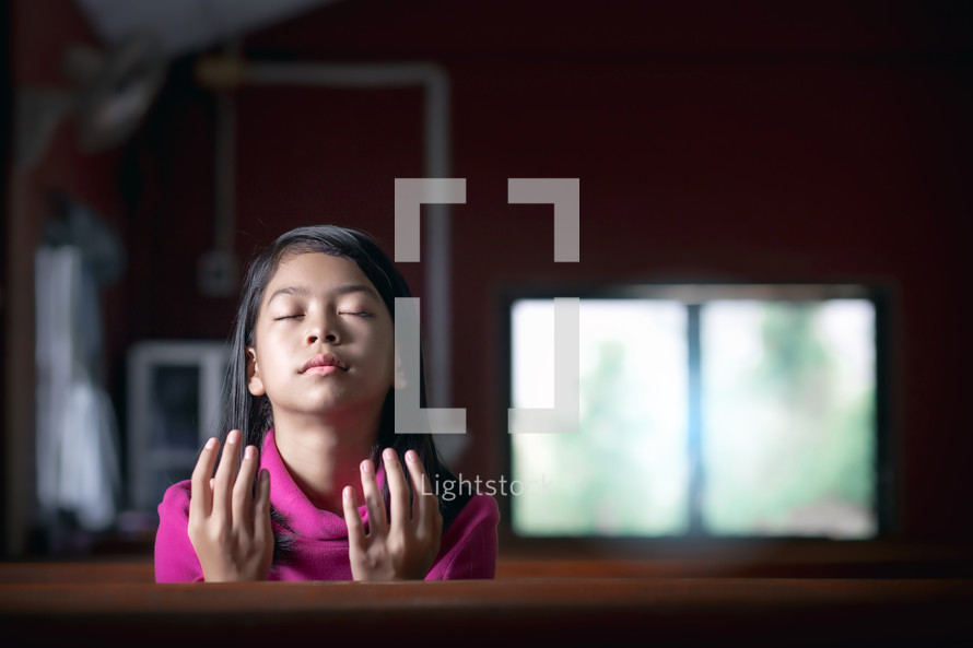 a girl praying in a church alone 