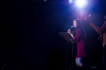 Female worship leader leading worship in a contemporary worship service