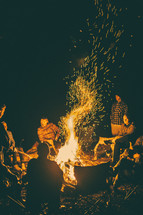 people sitting around a campfire 