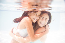 girls hugging under water 