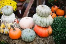 stacked pumpkins on a hay bale
