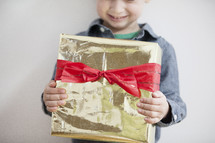 A child holding a wrapped Christmas gift. 
