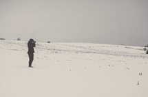 A man taking a picture with a camera in the snow 