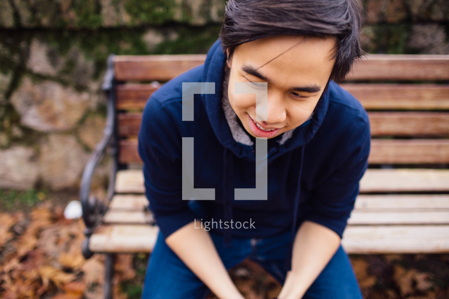 a man sitting and resting on a park bench 