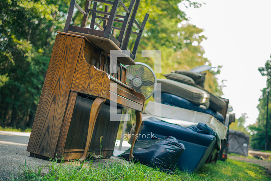 furniture and debris on the side of a road - cleaning up after flood damage 