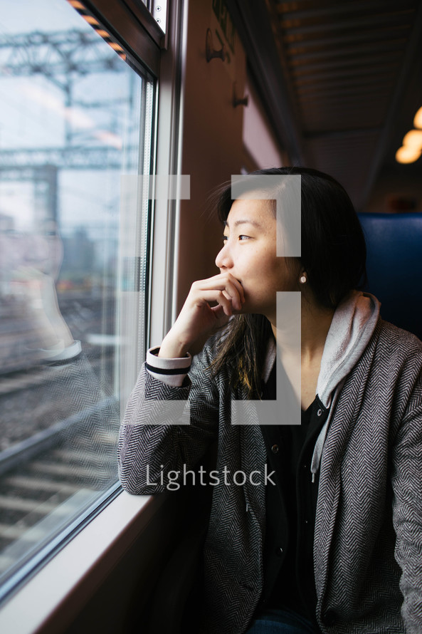 a woman looking out the window of a train 