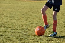 a kid kicking a soccer ball 