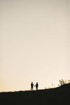 silhouette of a distant couple holding hands