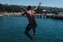a teen jumping into the ocean 