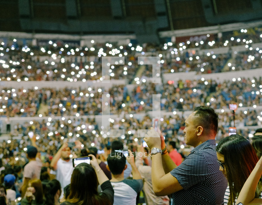 cellphone lights in a crowd at a concert 