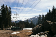 parked station wagon and snow capped mountains 