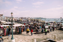 people gathered at a street market in the harbor of Venice
