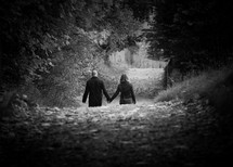 a couple walking outdoors holding hands 
