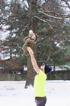father and infant outdoors in snow 