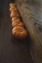 row of orange pumpkins on wood 