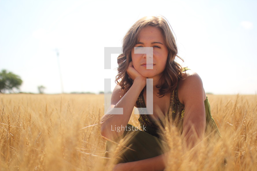 a young woman in a field of golden wheat