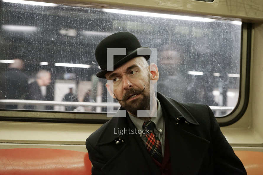 a man on a train with a top hat and mustache 