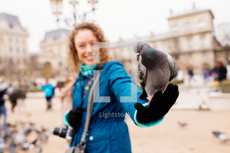 a pigeon on a woman's arm 