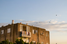birds flying over an beach condo roof 