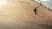 cross necklace on the pages of a Bible 