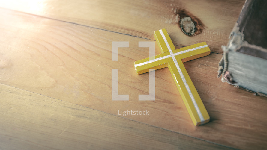 yellow cross on a wood table 