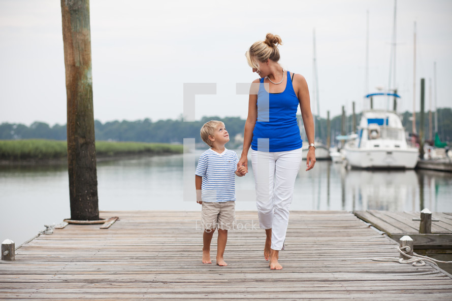 mother and son standing together on a dock at a marina 
