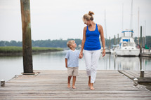 mother and son standing together on a dock at a marina 