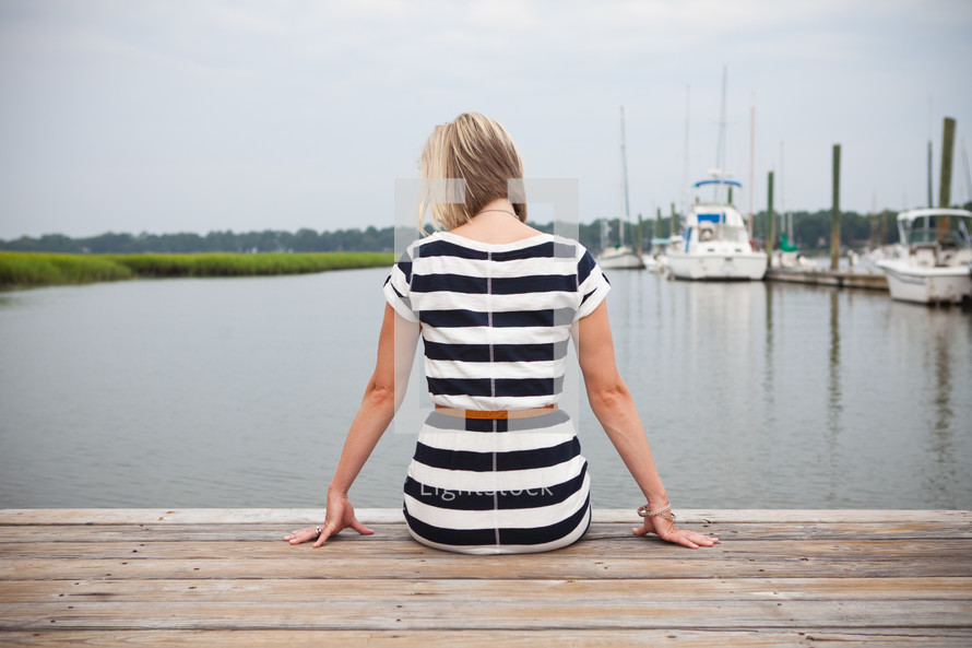 woman sitting at the end of a dock 