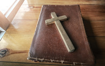 wooden cross on the cover of Bible 